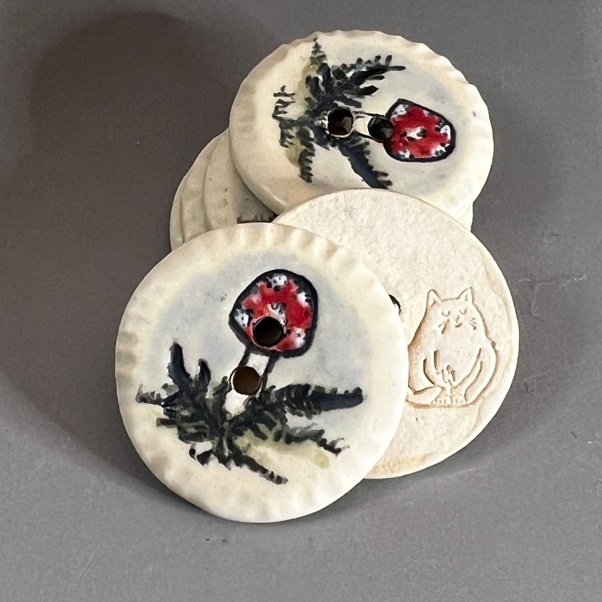 Red and White Cap Mushroom with Fern on White Round Button