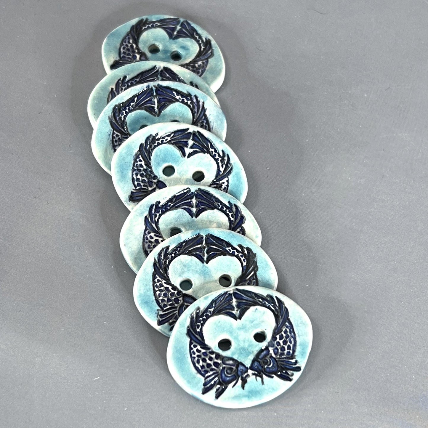 Two Koi Heart with Black Line Work on Light Blue Oval Button