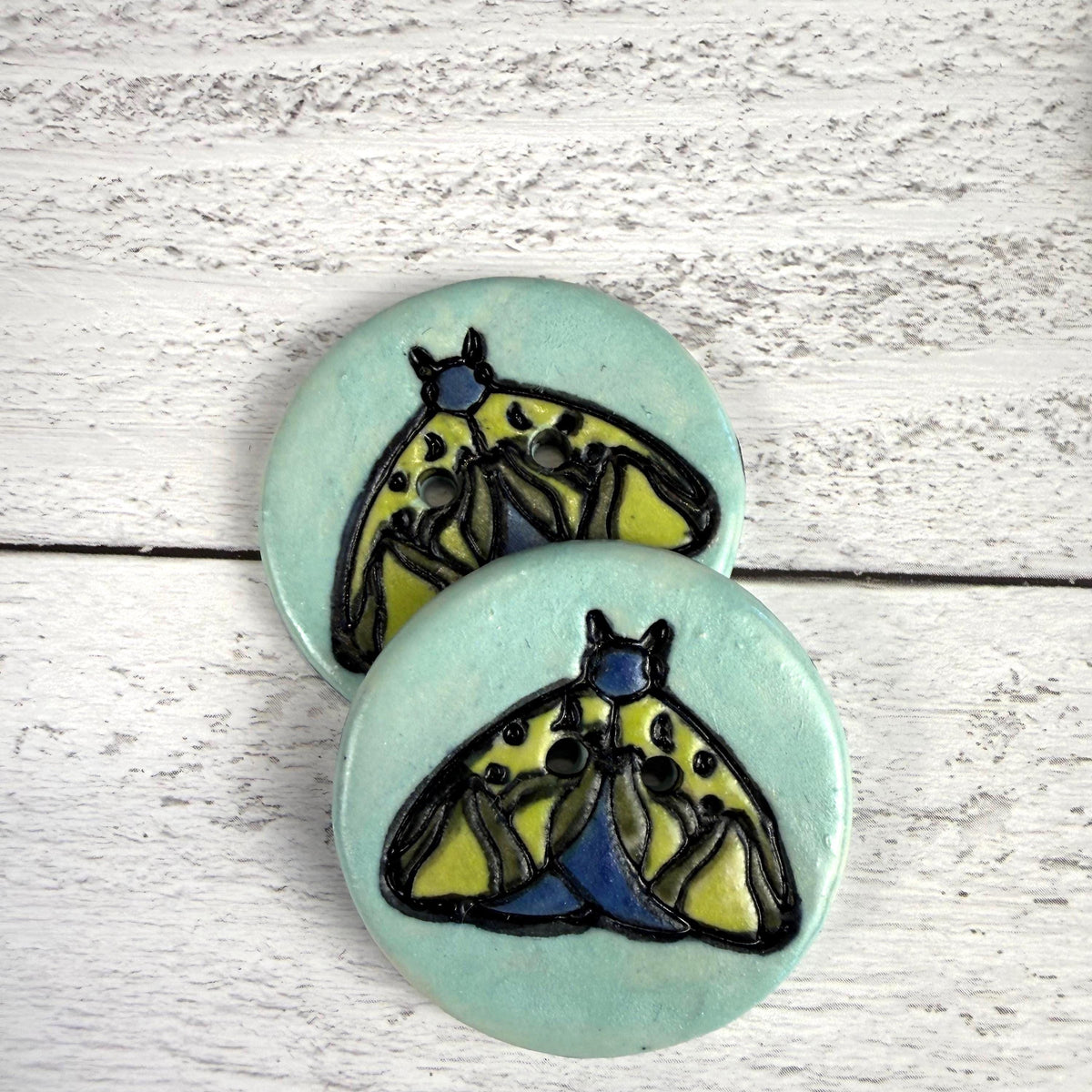 Dark Blue and Chartreuse Moth on Aqua Blue Ceramic Button