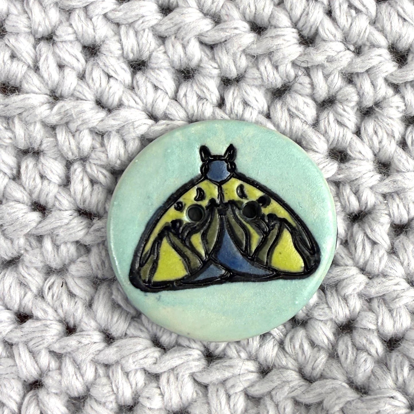 Dark Blue and Chartreuse Moth on Aqua Blue Ceramic Button