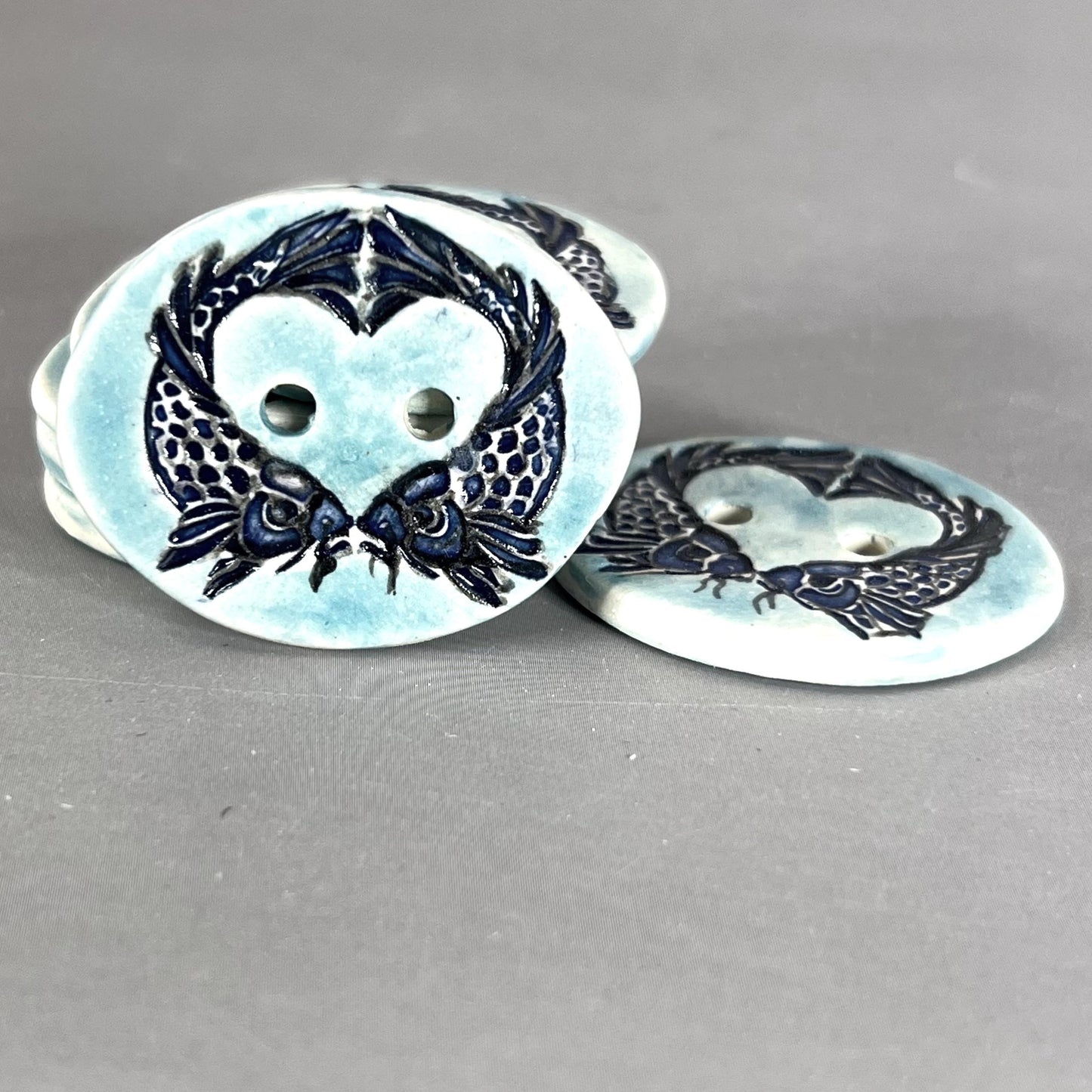 Two Koi Heart with Black Line Work on Light Blue Oval Button