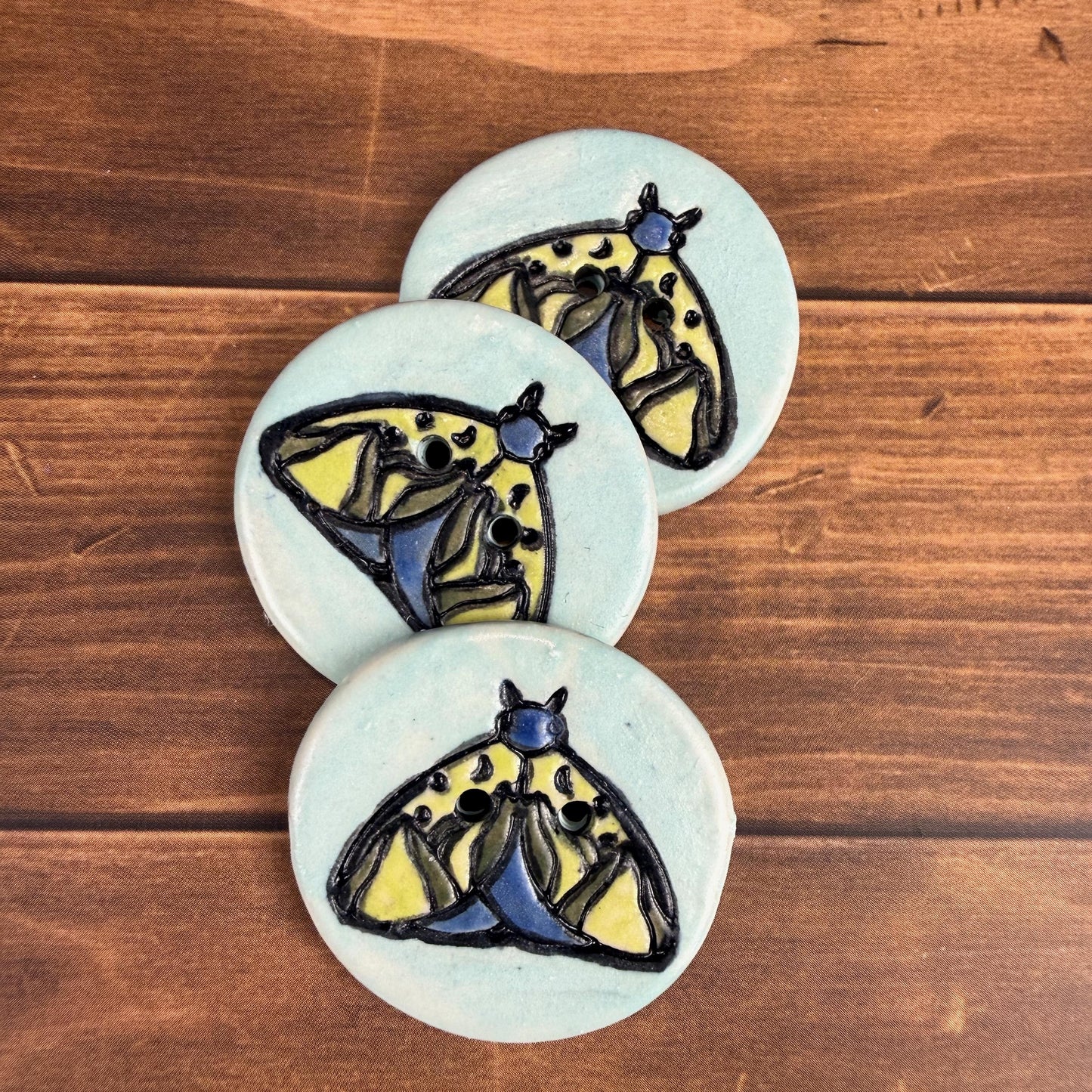 Dark Blue and Chartreuse Moth on Aqua Blue Ceramic Button