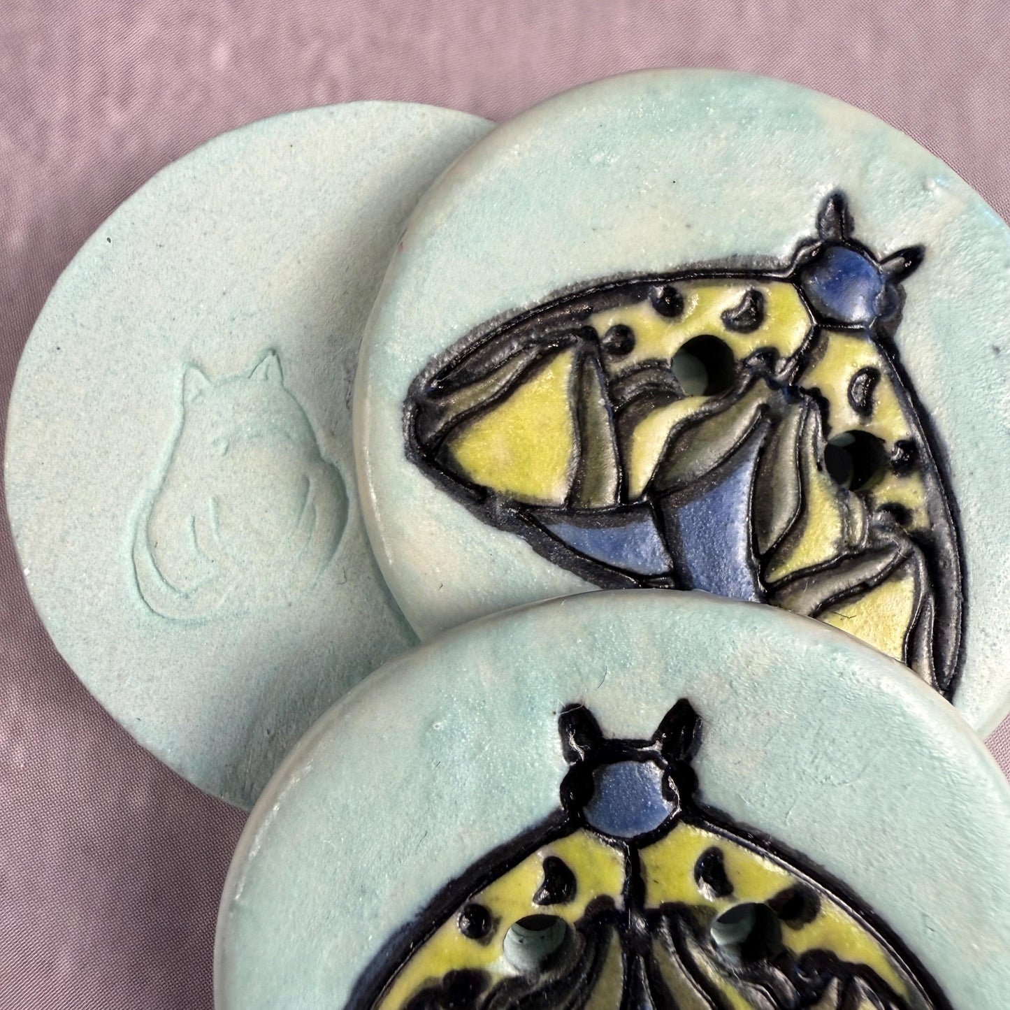 Dark Blue and Chartreuse Moth on Aqua Blue Ceramic Button