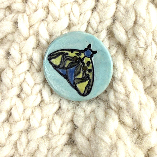 Dark Blue and Chartreuse Moth on Aqua Blue Ceramic Button
