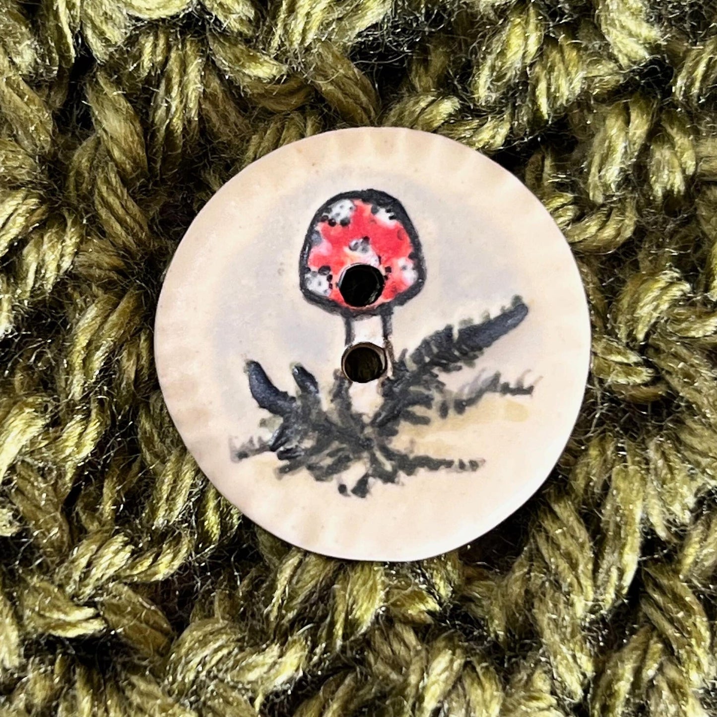 Red and White Cap Mushroom with Fern on White Round Button