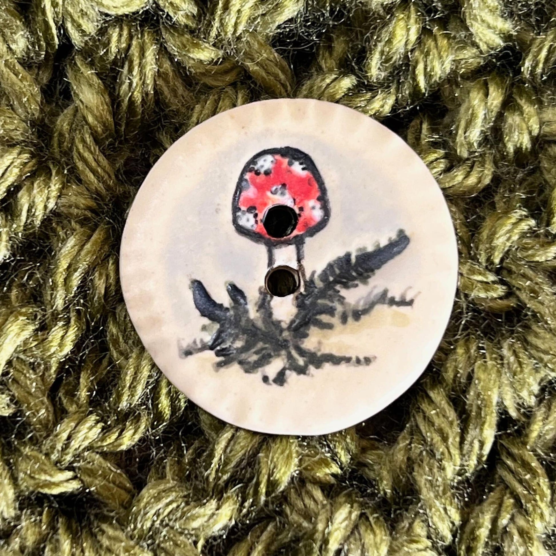 Red and White Cap Mushroom with Fern on White Round Button