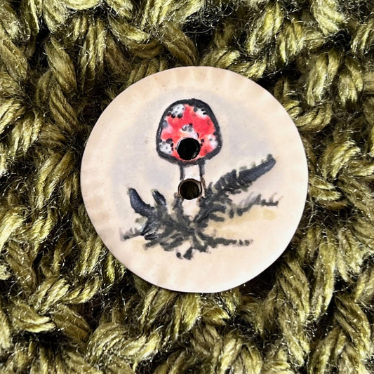 Red and White Cap Mushroom with Fern on White Round Button