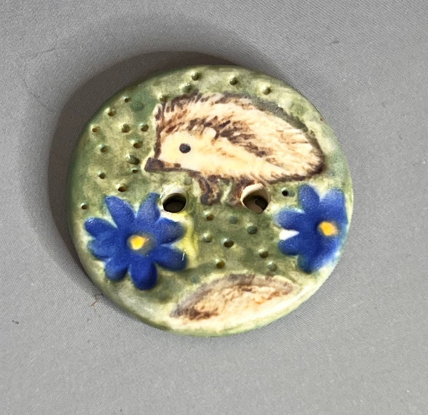 Hedgehog on Green Field with Blue Flowers Round Ceramic Button
