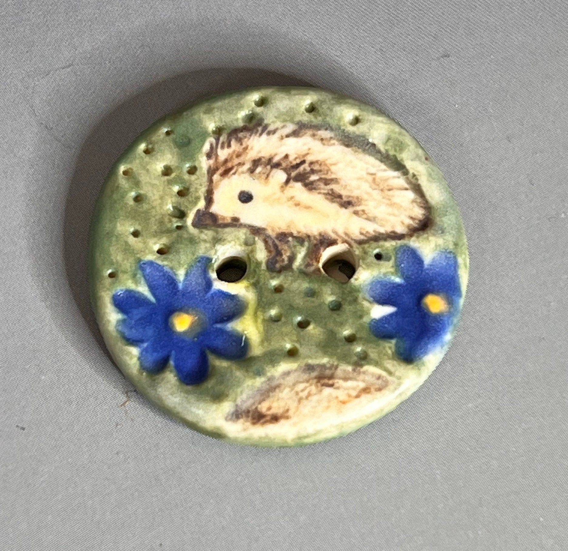 Hedgehog on Green Field with Blue Flowers Round Ceramic Button