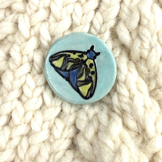 Dark Blue and Chartreuse Moth on Aqua Blue Ceramic Button