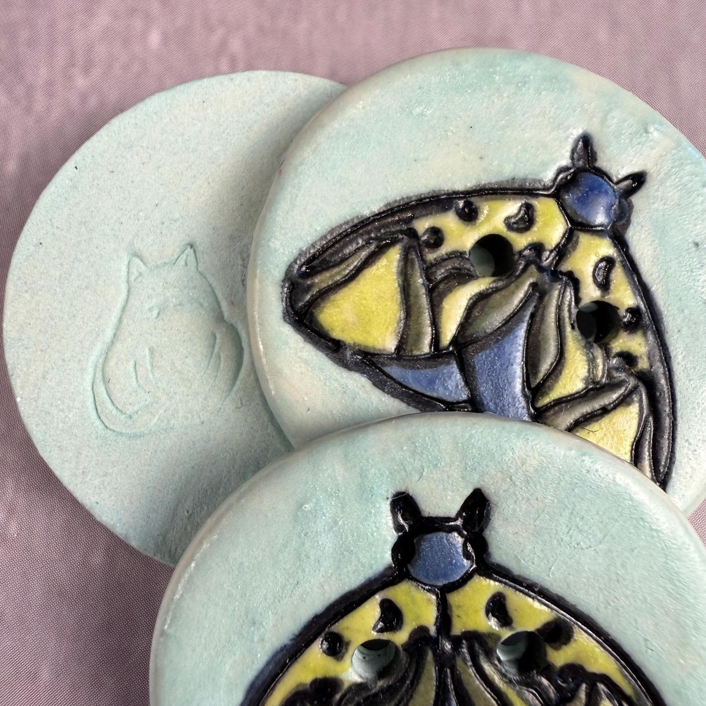 Dark Blue and Chartreuse Moth on Aqua Blue Ceramic Button