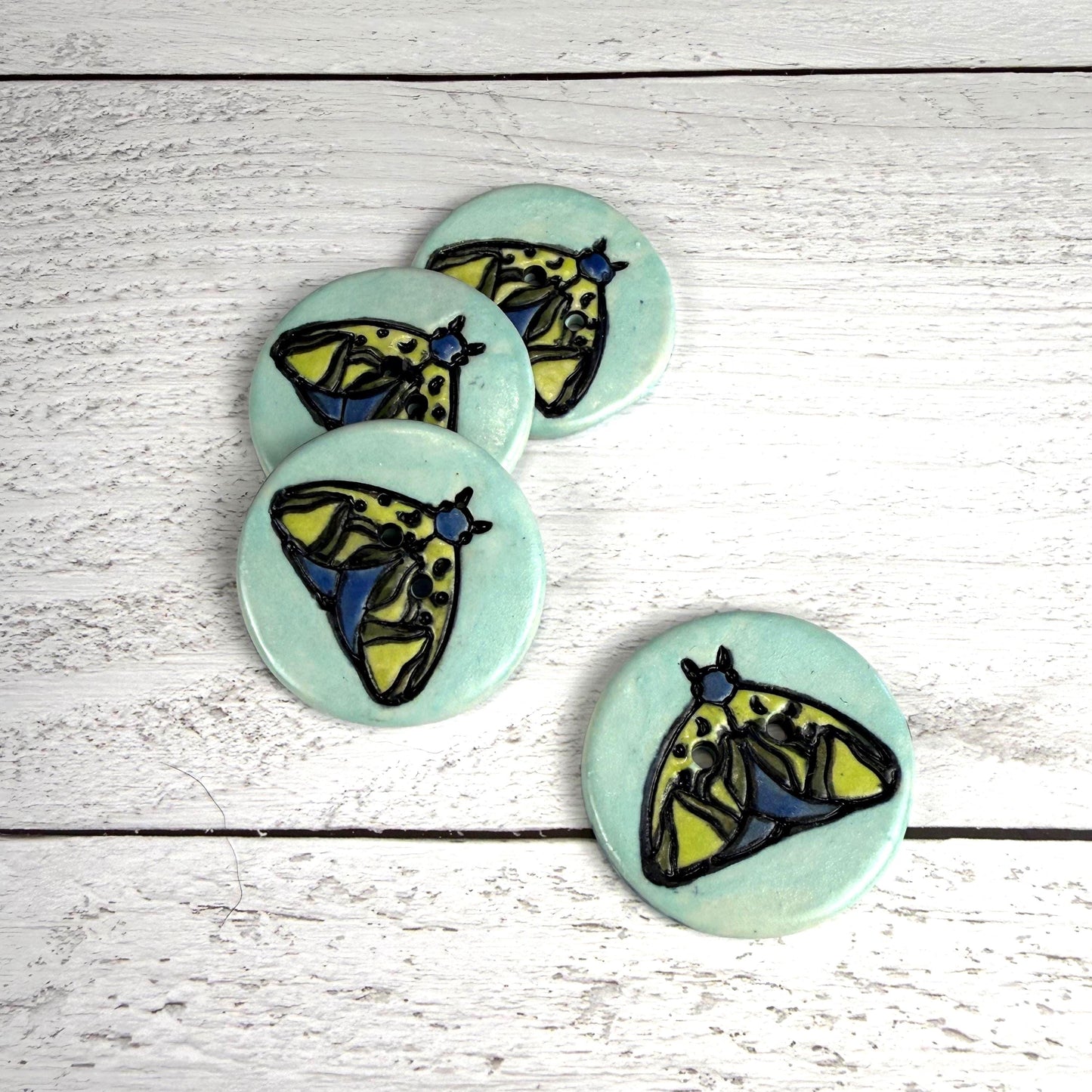 Dark Blue and Chartreuse Moth on Aqua Blue Ceramic Button